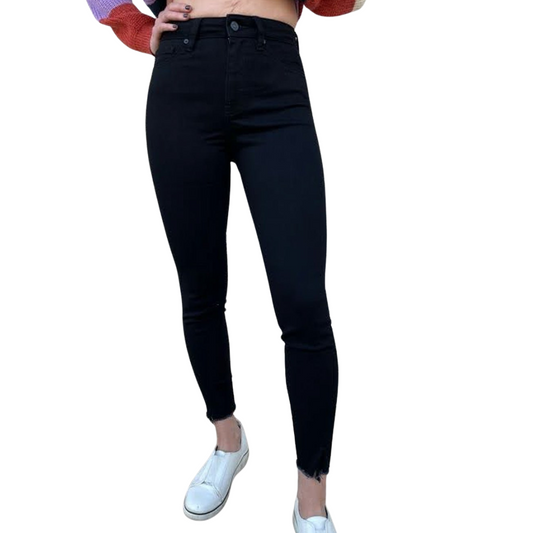 black high-rise skinny jeans with raw hem — front view